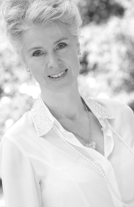 Smiling therapist with white blouse in front of nature background